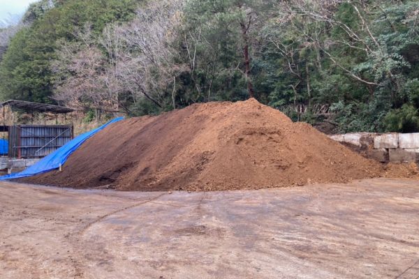 椎茸栽培後の木質原料を野外で発酵・熟成している様子